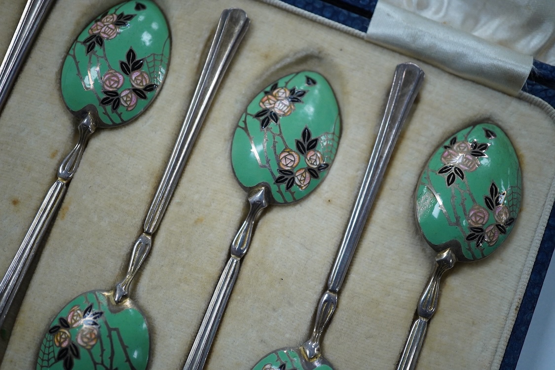 A cased set of six George V Art Deco silver and enamel coffee spoons, By Turner & Simpson, Birmingham, 1933, 98mm, the bowl backs decorated with a rose bush with spider's web.